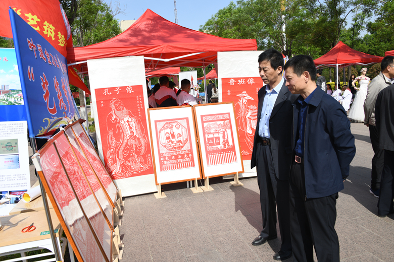 10.聊城职业技术学院院徐龙海聊城市政府办公室副主任李猷春观看学生剪纸作品.JPG